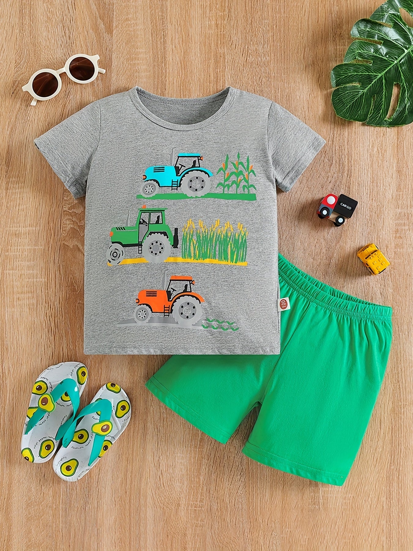Conjunto de menino casual com estampado de tratores, composto por t-shirt de gola redonda e calções. Ideal para o dia a dia e para atividades ao ar livre.