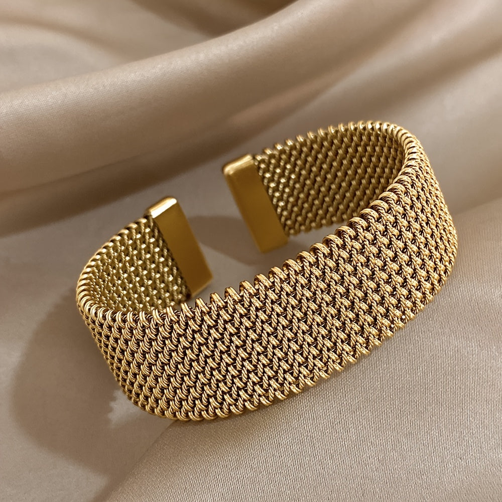 Nova bracelete moderna em aço inoxidável entrançado com um toque dourado. Acessório elegante num tom dourado versátil.