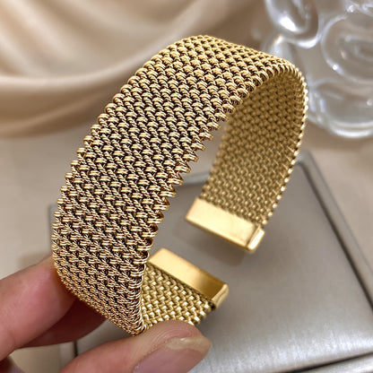 Nova bracelete moderna em aço inoxidável entrançado com um toque dourado. Acessório elegante num tom dourado versátil.