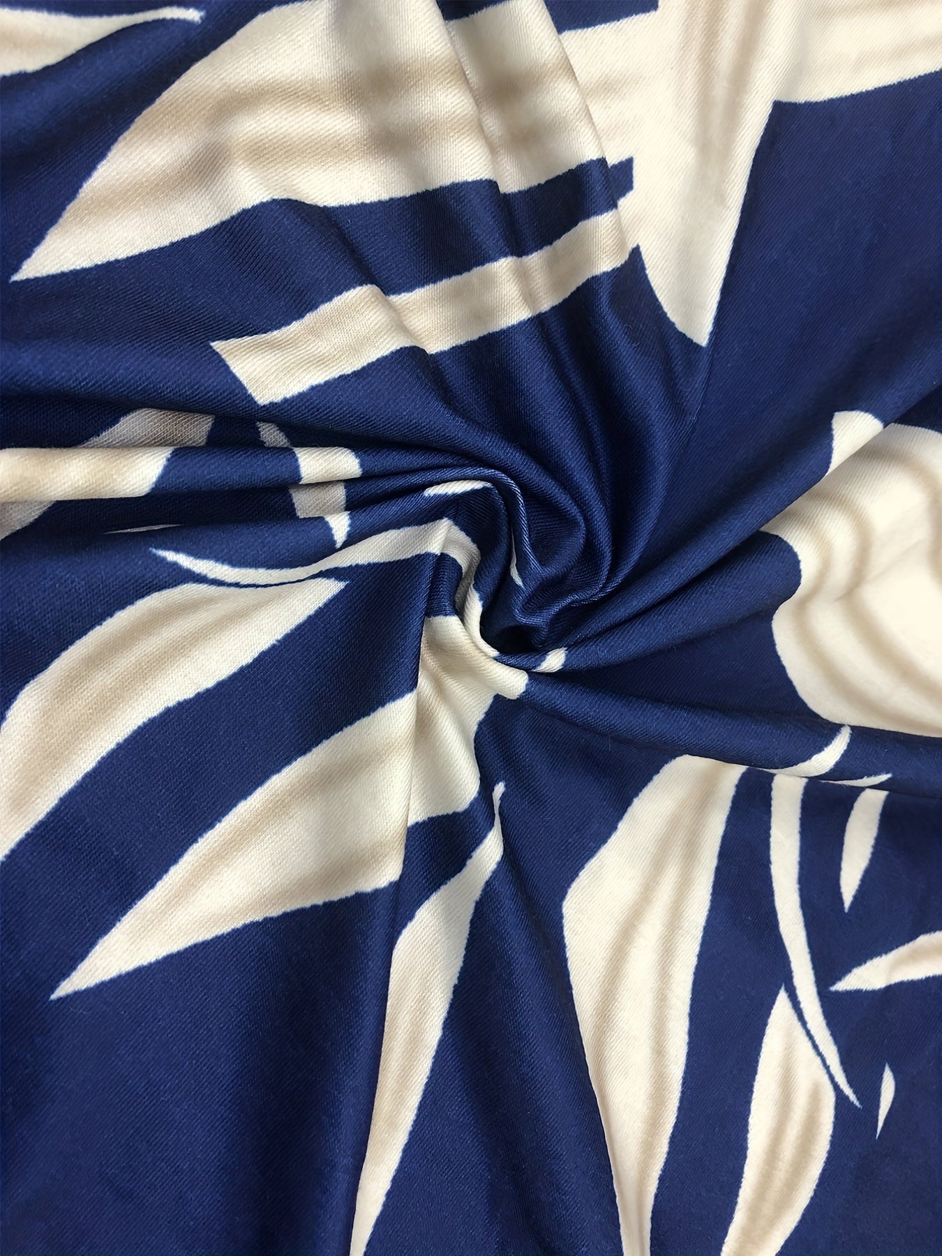 Vestido casual plus size para menina com estampado de folhas, detalhe de argola, mangas recortadas, gola redonda, corte alto e evasé frontal.