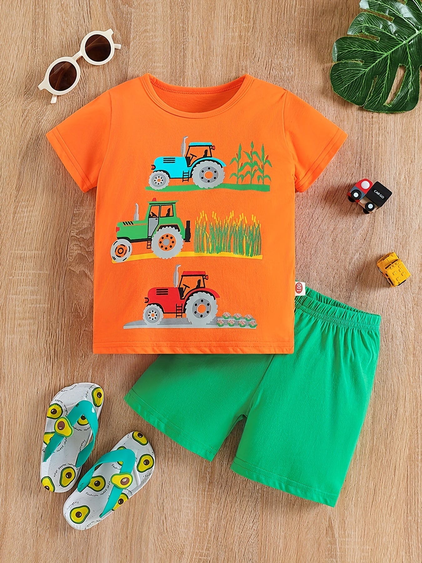 Conjunto de menino casual com estampado de tratores, composto por t-shirt de gola redonda e calções. Ideal para o dia a dia e para atividades ao ar livre.