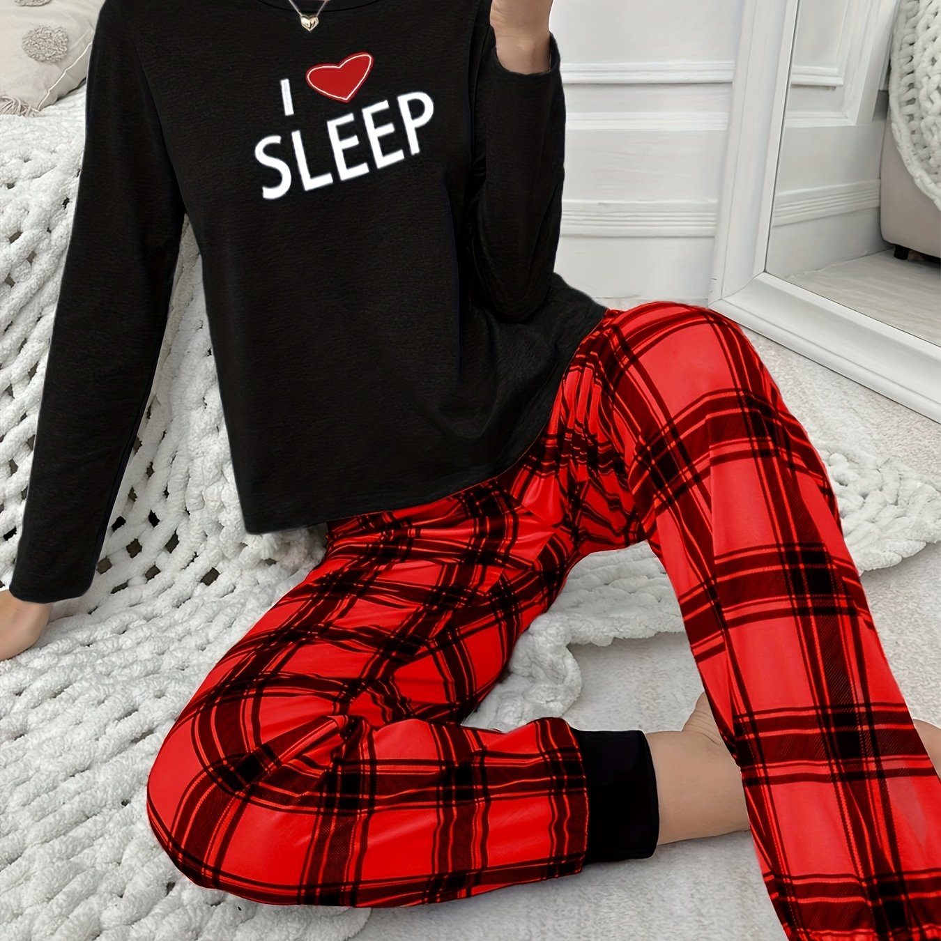 Conjunto de pijama para menina para o outono e inverno com mangas compridas, calças e estampado xadrez de corações e letras em estilo cartoon.