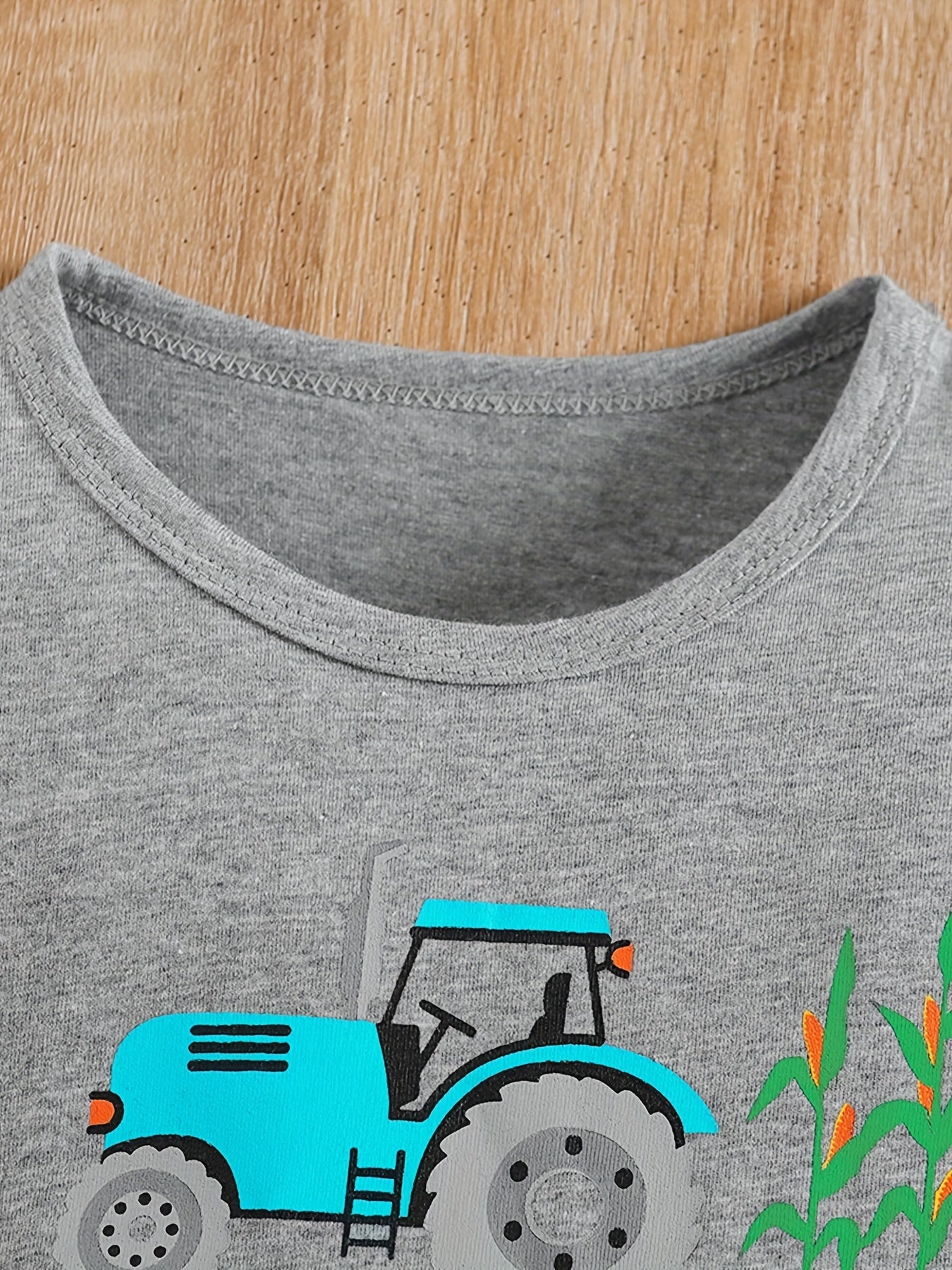 Conjunto de menino casual com estampado de tratores, composto por t-shirt de gola redonda e calções. Ideal para o dia a dia e para atividades ao ar livre.