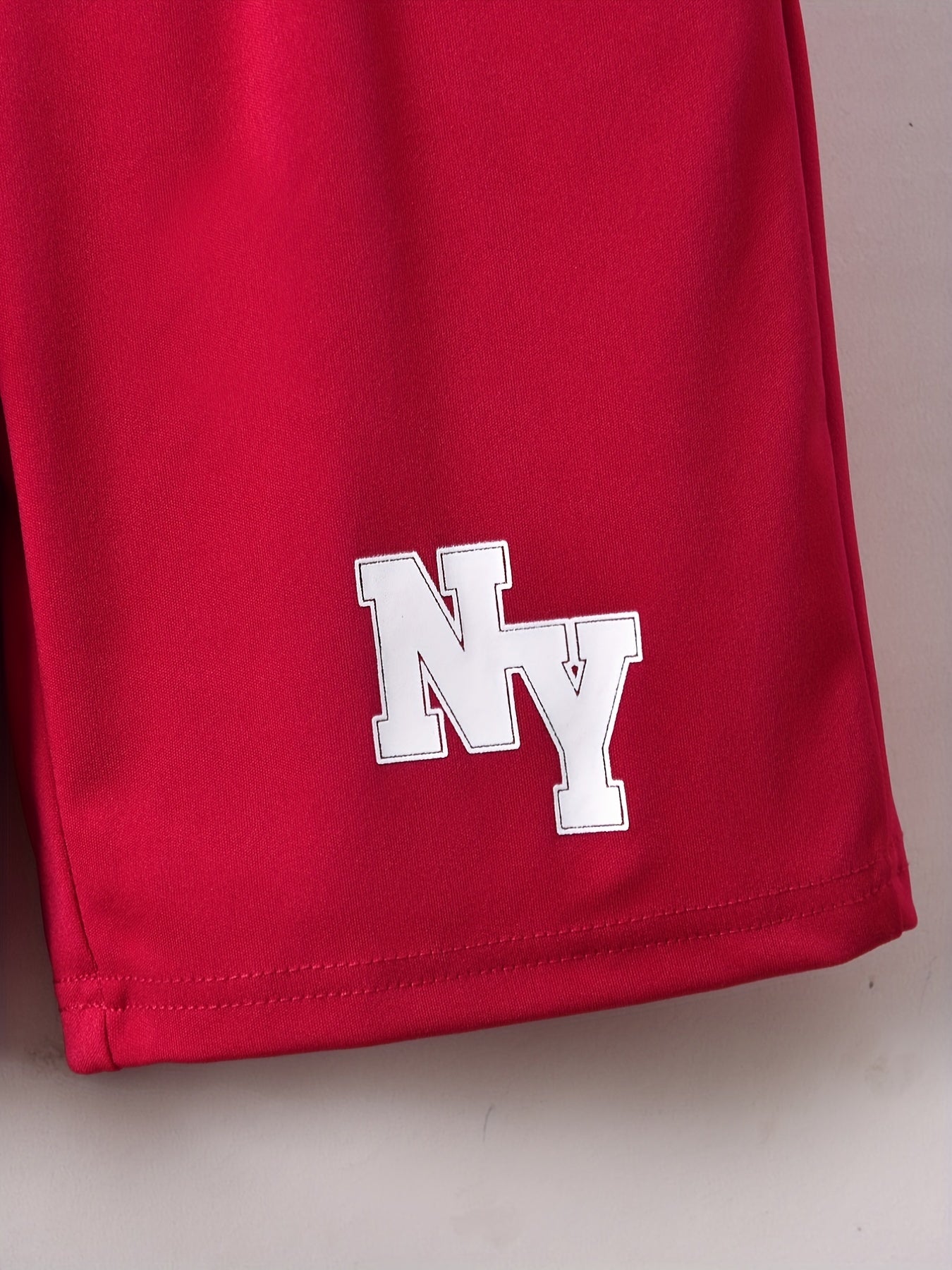 Conjunto elegante de t-shirt de manga curta com estampado de letras e calções para menino, ideal para atividades ao ar livre.