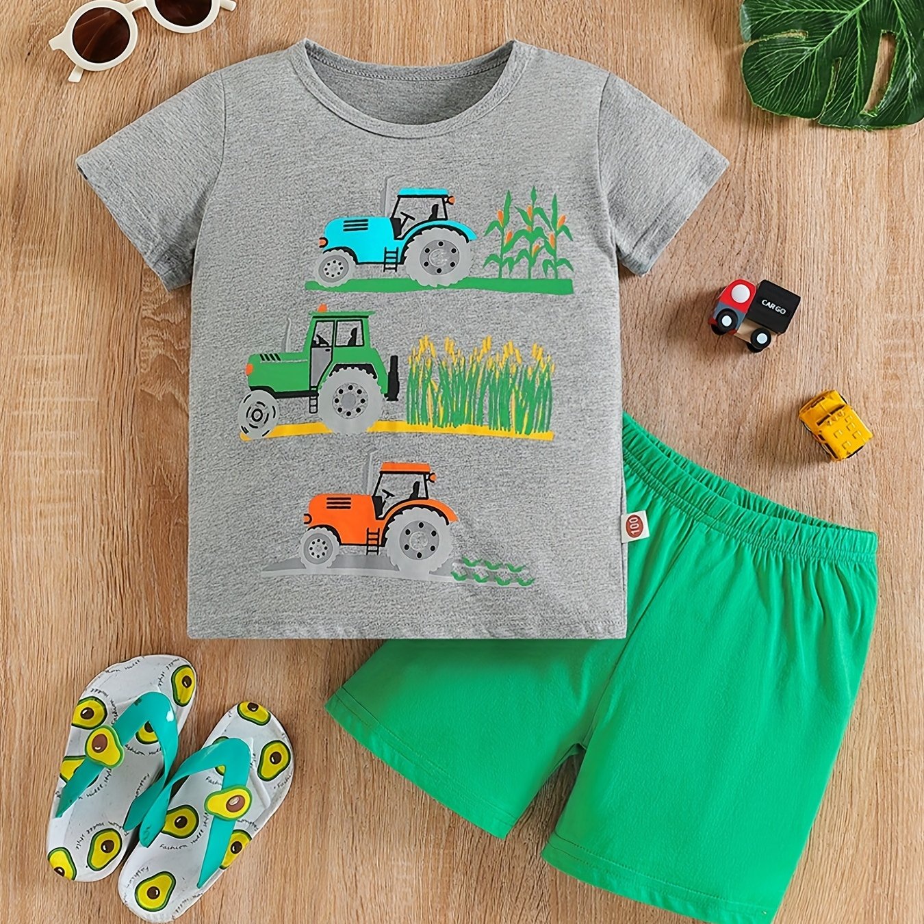 Conjunto de menino casual com estampado de tratores, composto por t-shirt de gola redonda e calções. Ideal para o dia a dia e para atividades ao ar livre.