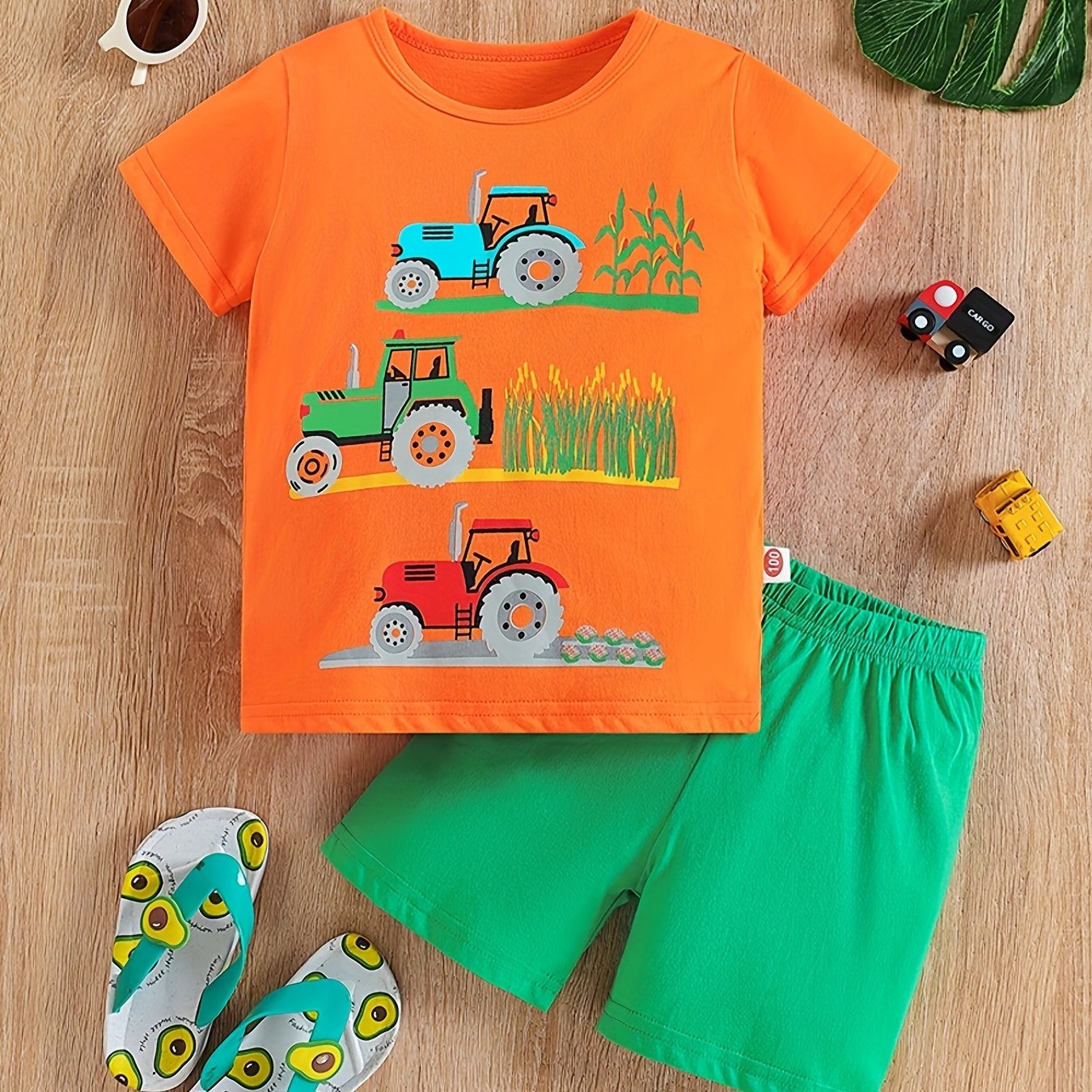 Conjunto de menino casual com estampado de tratores, composto por t-shirt de gola redonda e calções. Ideal para o dia a dia e para atividades ao ar livre.