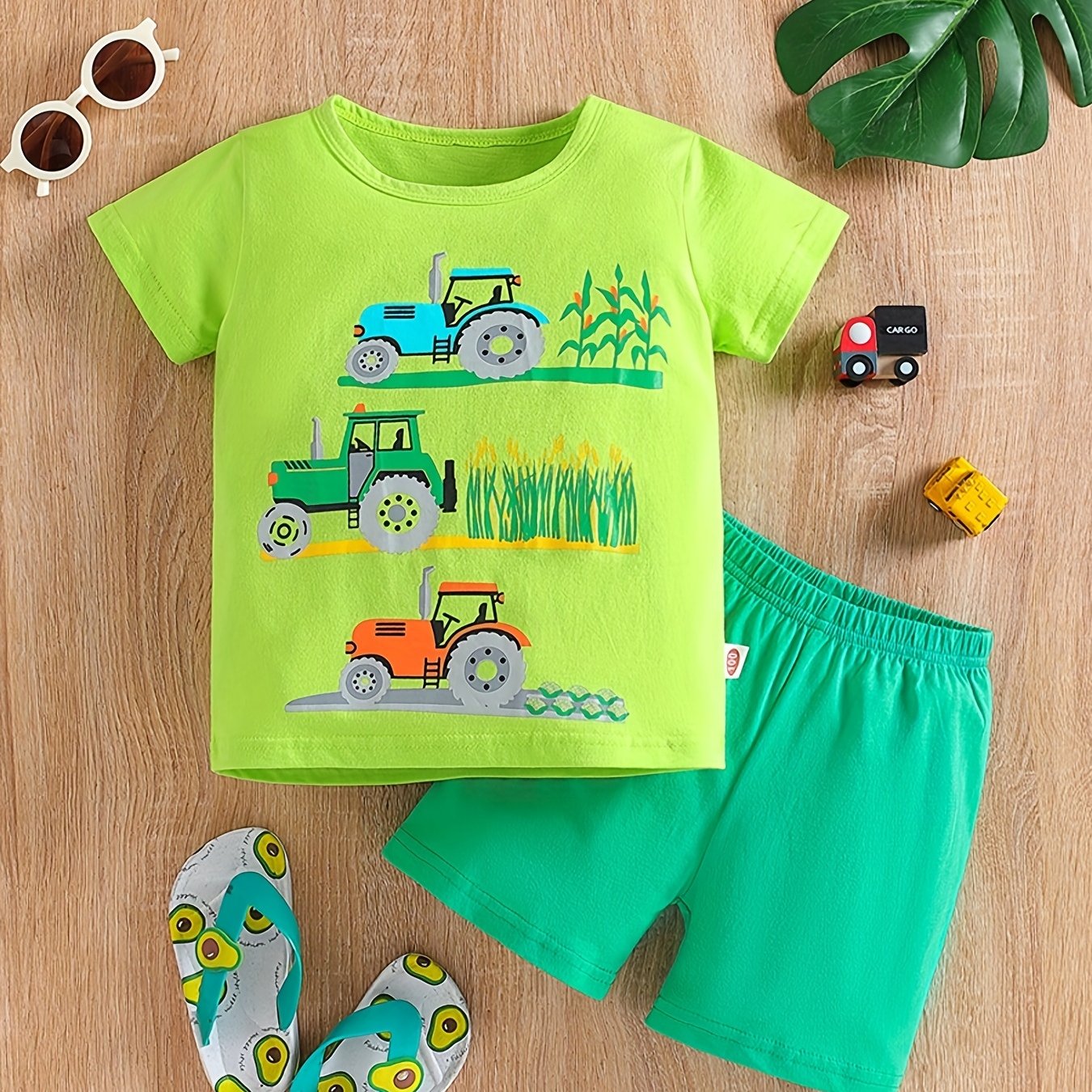 Conjunto de menino casual com estampado de tratores, composto por t-shirt de gola redonda e calções. Ideal para o dia a dia e para atividades ao ar livre.