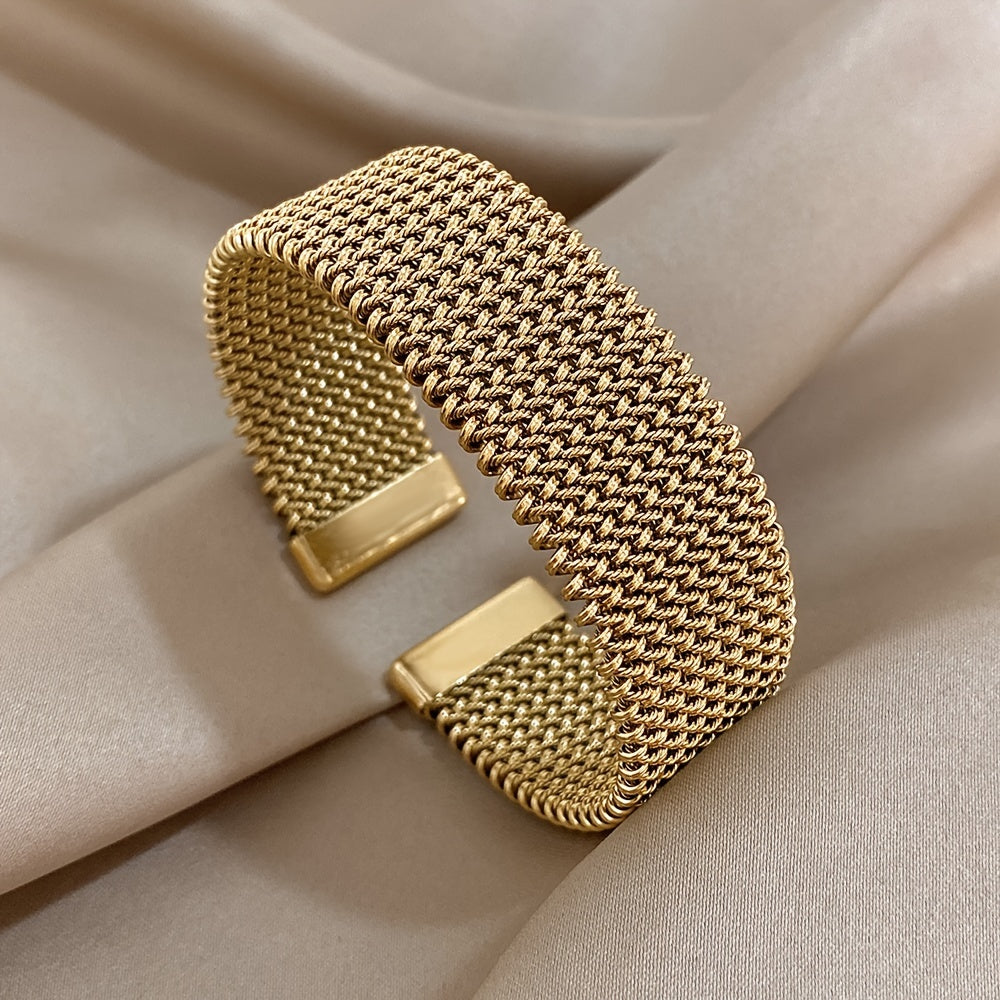 Nova bracelete moderna em aço inoxidável entrançado com um toque dourado. Acessório elegante num tom dourado versátil.