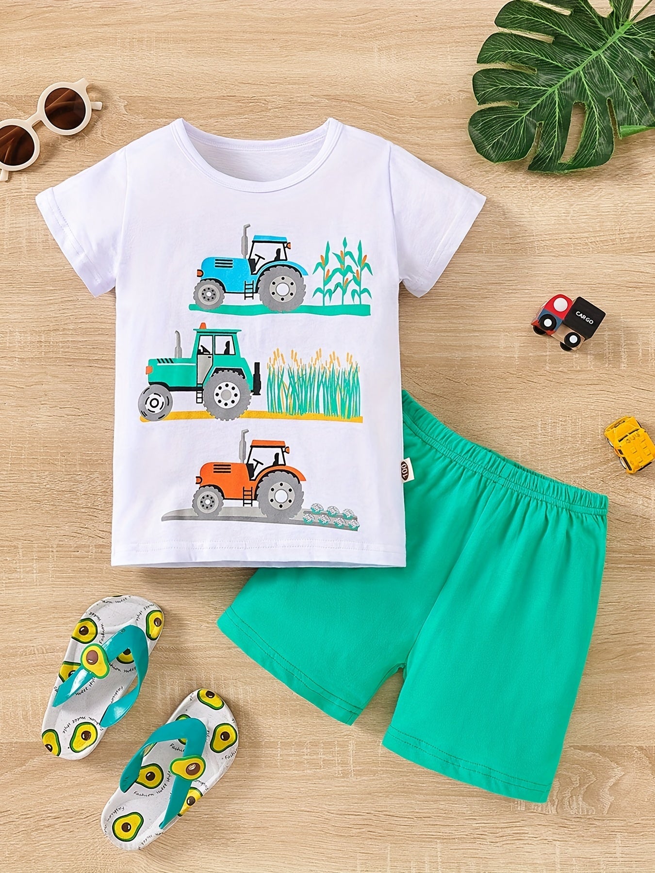 Conjunto de menino casual com estampado de tratores, composto por t-shirt de gola redonda e calções. Ideal para o dia a dia e para atividades ao ar livre.
