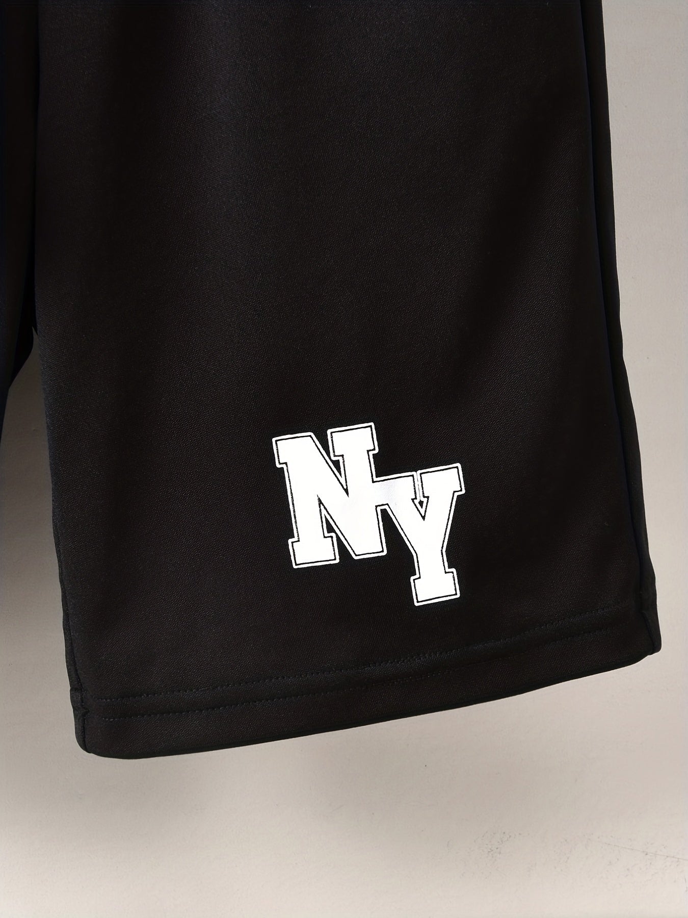 Conjunto elegante de t-shirt de manga curta com estampado de letras e calções para menino, ideal para atividades ao ar livre.