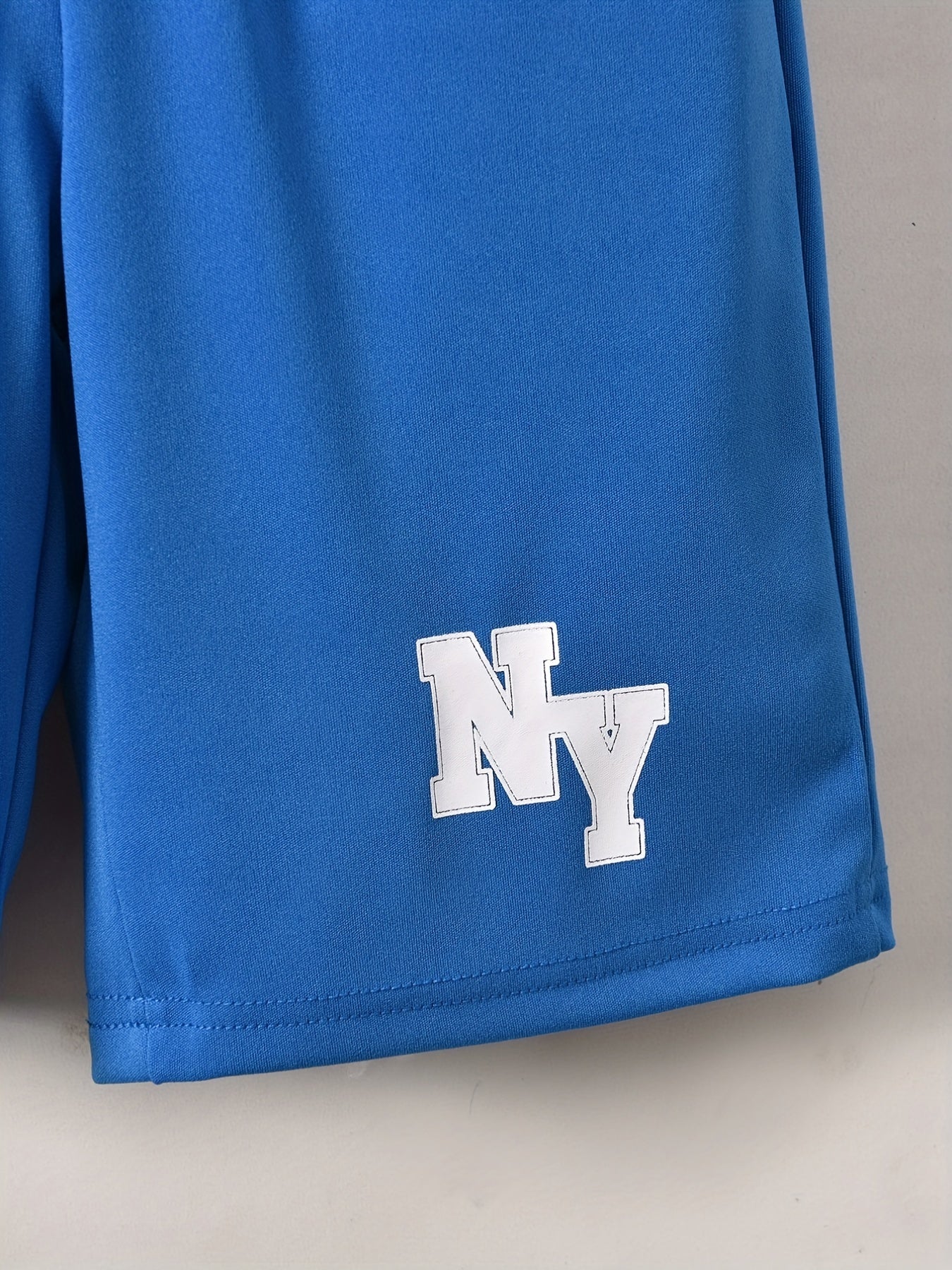 Conjunto elegante de t-shirt de manga curta com estampado de letras e calções para menino, ideal para atividades ao ar livre.