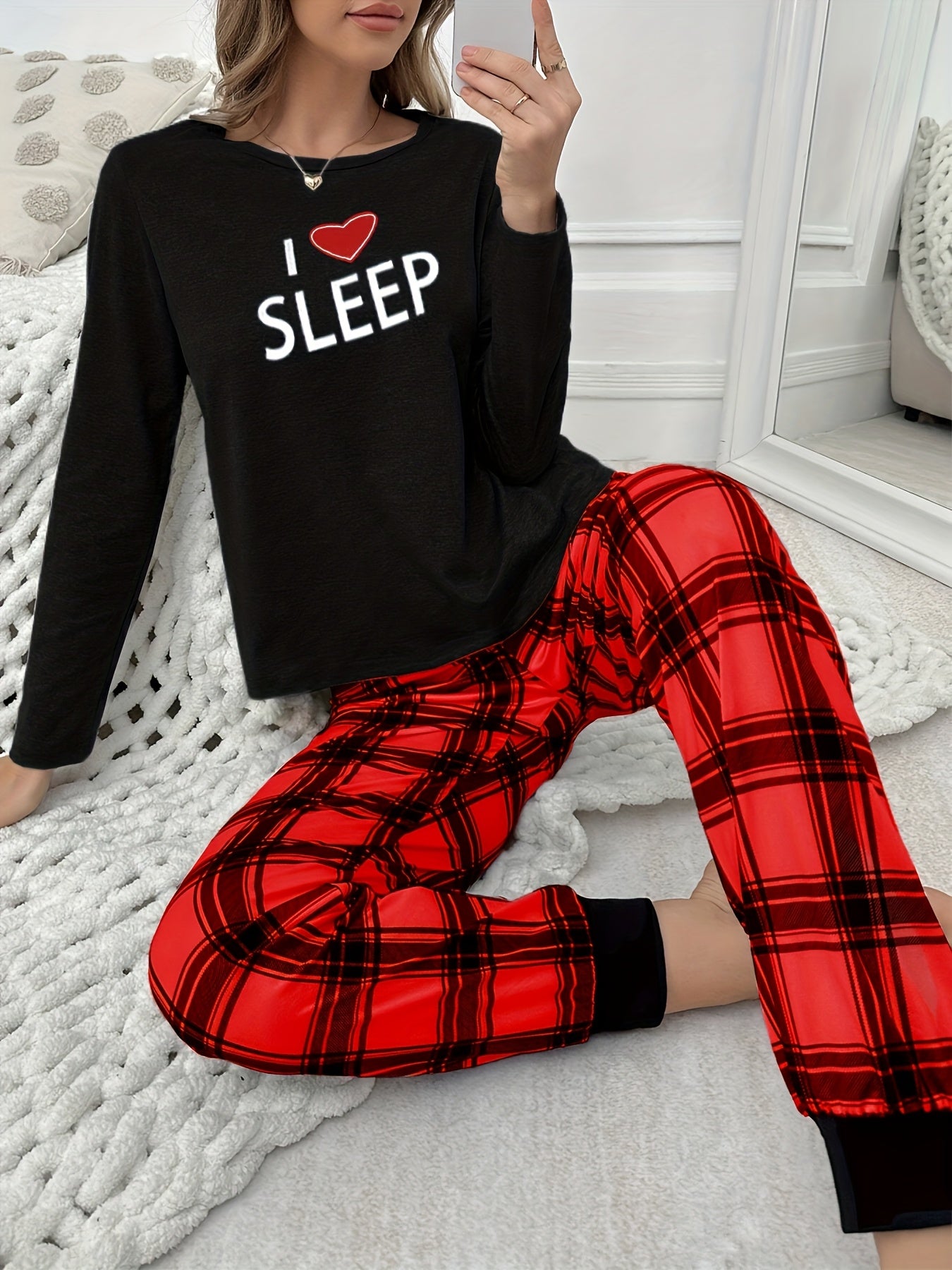Conjunto de pijama para menina para o outono e inverno com mangas compridas, calças e estampado xadrez de corações e letras em estilo cartoon.