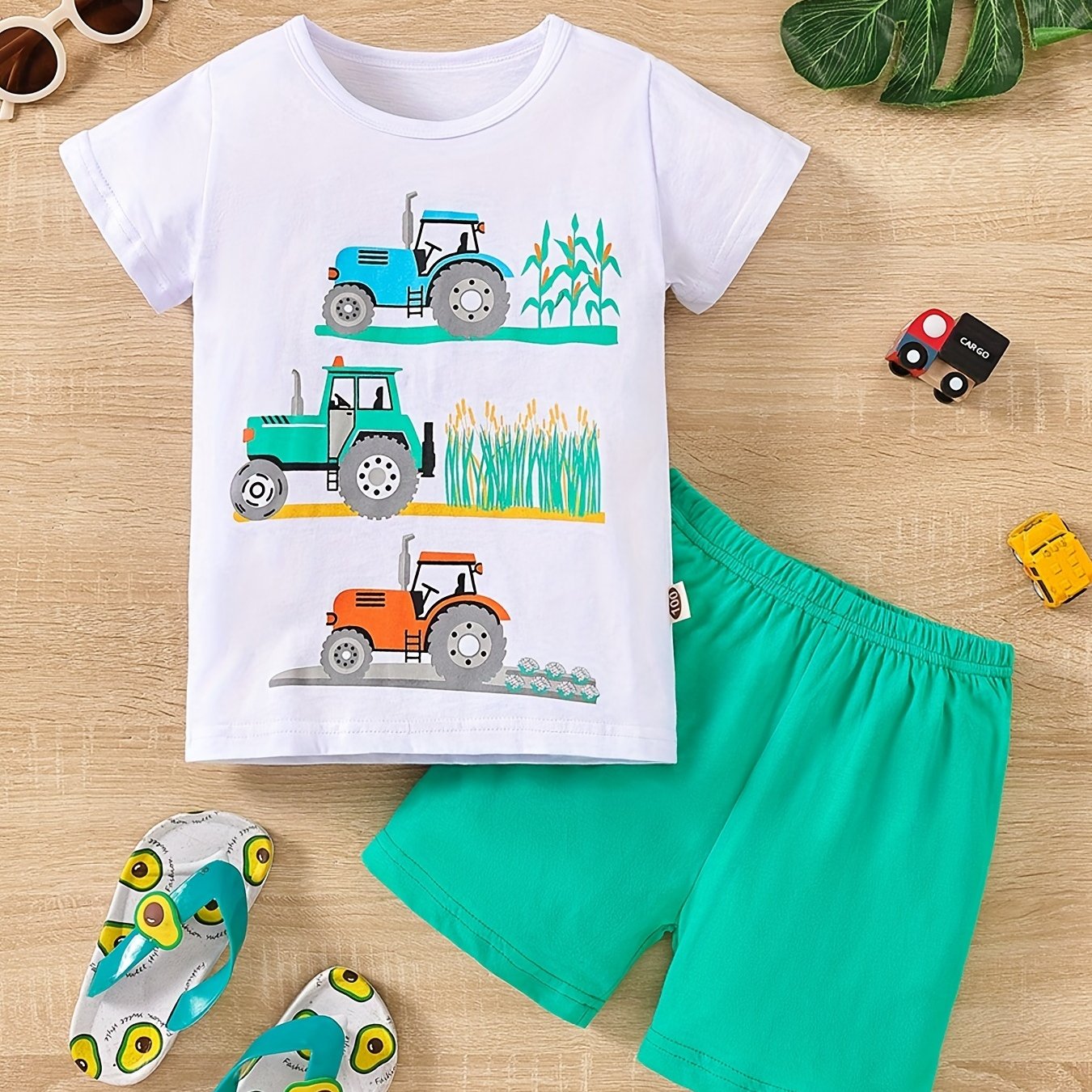 Conjunto de menino casual com estampado de tratores, composto por t-shirt de gola redonda e calções. Ideal para o dia a dia e para atividades ao ar livre.
