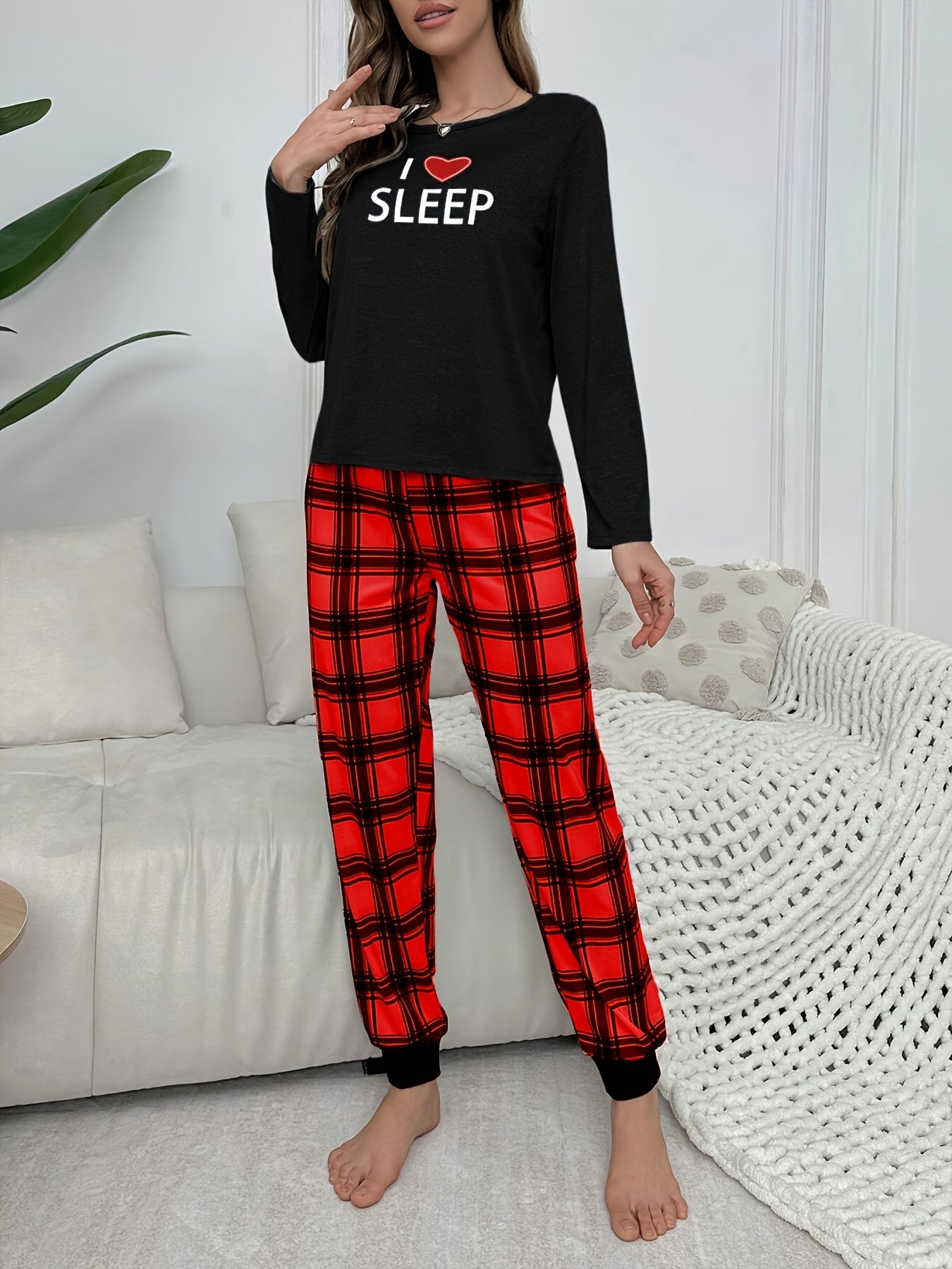 Conjunto de pijama para menina para o outono e inverno com mangas compridas, calças e estampado xadrez de corações e letras em estilo cartoon.