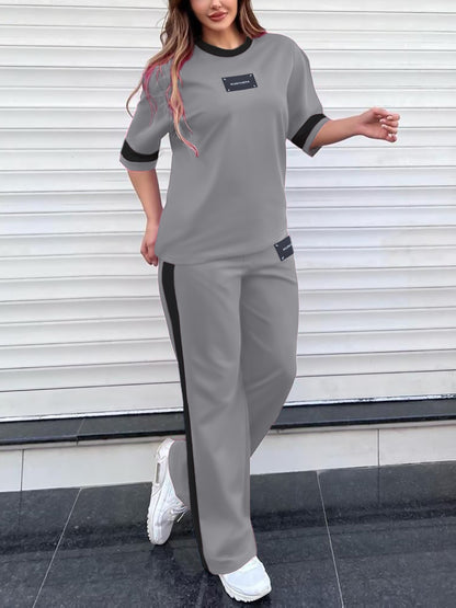 Tendência de moda outono: Conjunto de duas peças para menina composto por t-shirt de manga curta com gola redonda e blocos de cor + calças direitas casuais com cintura elástica e corte largo.